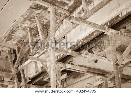 Building under construction made from wood and steel to cement;sepia tone