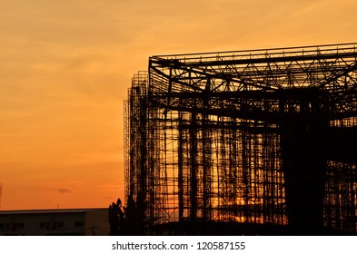 Building under construction with sunset background.