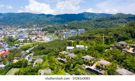 Building under construction surrounded by green mountains in sunny weather.  