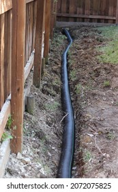 Building an Underground French Drain System after Digging the trench system to keep water away from home's foundation. Drainage ditch. Laying a drainage pipe. Earthwork.