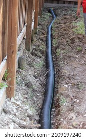 Building an Underground French Drain System after Digging the trench system to keep water away from home's foundation. Drainage ditch. Laying a drainage pipe. Earthwork.