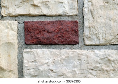 Building wall made of light bricks and one dark brick