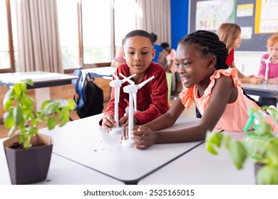 Building wind turbine models in school classroom, diverse children engaging in STEM activities. education, renewable energy, learning, science, engineering, teamwork - Powered by Shutterstock