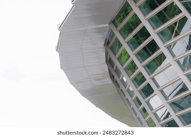 A building with a lot of windows and a reflection of trees in th