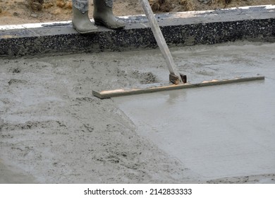 A Building Worker Bull-floating The Wet Concrete