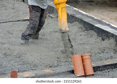 A Building Worker Pouring A Concrete Slab Foundation Using A Hose Of A Concrete Pump Truck