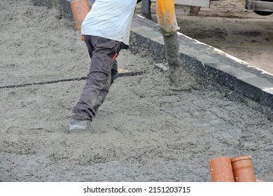 A Building Worker Pouring A Concrete Slab Foundation Using A Hose Of A Concrete Pump Truck