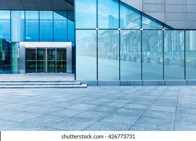 buildings and clean road reflected on the glass wall