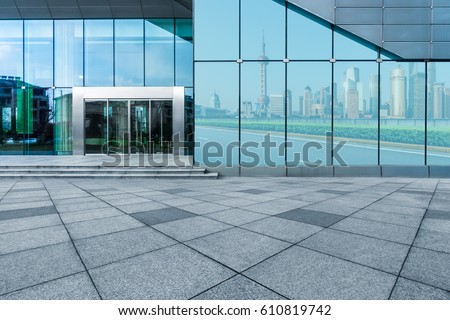 buildings and clean road reflected on the glass wall
