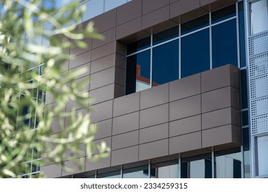A building's facade cladding with composite panels and glass windows