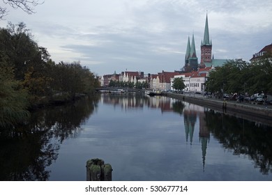 buildings of luebeck mirrored in a small pond