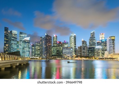 Buildings and  Marina bay in the city at night - Shutterstock ID 396649798