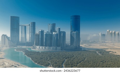 Buildings on Al Reem island in Abu Dhabi timelapse from above. Aerial cityscape of Al Reem Island, showing the reflection of buildings in the water and shadows with fog - Powered by Shutterstock