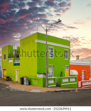 Buildings on a corner, with a dramatic sunset sky in the background, showcasing architectural beauty and vibrant hues in the cultural meca of Bo-Kaap South Africa located in Cape Town.