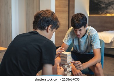Builing unstable tower from wooden blocks.Two players play a strategic game of building a tower from the wooden blocks.Strategic social game