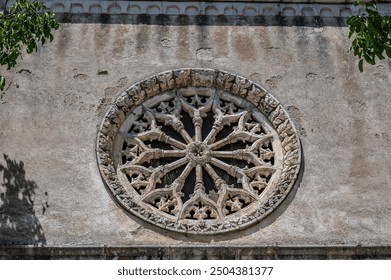 Built in 1602, the facade is made of stone blocks and features a Gothic-style rose window. The door is surmounted by a lunette with a painting of St. Nicholas and the Madonna with Child. - Powered by Shutterstock