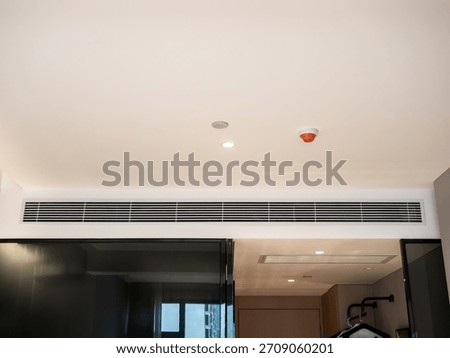 Built-in ceiling air conditioning vent in modern hotel room, representing efficient HVAC system, comfortable guest experience, luxury interior design, and professional climate control installation.