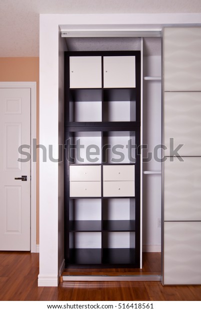 Built-in closet with sliding door shelving\
storage organization solution, empty\
shelves