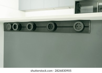 Built-in horizontal socket panel mounted into a kitchen counter for connecting domestic appliances. Perfect stock photo for kitchen ergonomics, home technology, and electrical hardware