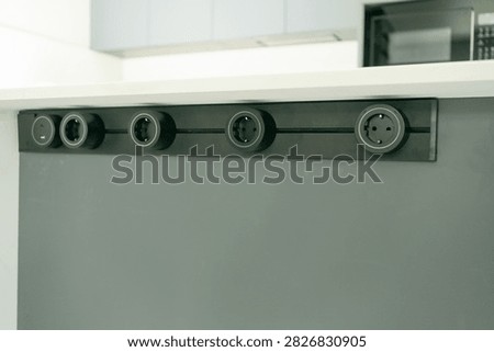 Built-in horizontal socket panel mounted into a kitchen counter for connecting domestic appliances. Perfect stock photo for kitchen ergonomics, home technology, and electrical hardware