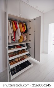 built-in wardrobe with hanging outerwear, garment and shoe drawer shelves in white room