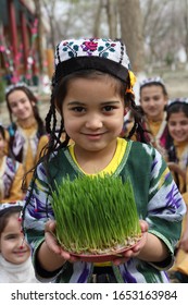 Bukhara.Uzbekistan.19.03.2018. A girl shows sprouted wheat grains for sumalak, Navruz holiday in Bukhara. Uzbekistan.