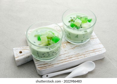 Buko Pandan, a dessert from Philippines, made from jelly, young coconut, evaporated milk, sweetened condensed milk, and ice. Served in glass on grey background. Selective focus. Copy space.