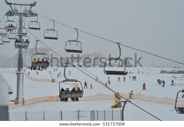 BUKOVEL, UKRAINE - DEC 04, 2016: Skiers on\
a cable car in Bukovel. Bukovel is the most popular ski resort in\
Ukraine. Ski season and Winter sports\
concept