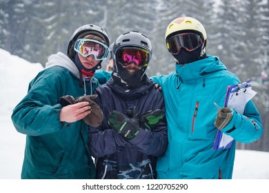 BUKOVEL,UKRAINE-19 MARCH,2018: Winter Action Sports Festival In Snow Park.Young People Compete In Big Air Snowboarding & Extreme Skiing.Group Of Athletes In Warm Jackets & Protective Helmets Posing