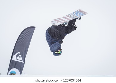 BUKOVEL,UKRAINE-20 MARCH,2018: Snowboard Contest In Winter Park.Young Athletes Compete In Snowboarding.Cool Extreme Sport Competition For Youth.Rider Performs Backflip Rodeo Air Trick On Ramp