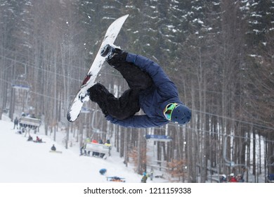 BUKOVEL,UKRAINE-20 MARCH,2018: Snowboard Contest In Winter Park.Young Athletes Compete In Snowboarding.Cool Extreme Sport Competition For Youth.Rider Performs Rodeo Backflip Trick In The Air