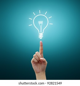 Bulb light on women Fingertip on blue background - Shutterstock ID 92821549