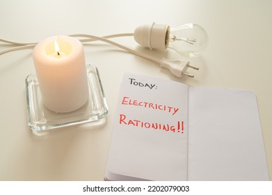 Bulb off, with a lit candle beside it, and a diary page with the text "Today: electricity rationing". Rationing of energy, shortage of energy and gas, increase in tariffs.
 - Shutterstock ID 2202079003