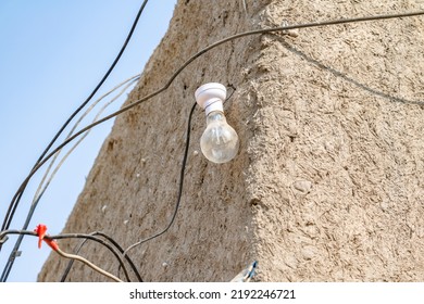 A Bulb Without Electricity Is Hanging On A Muddy Wall In The Village