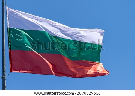 Bulgarian national flag waving on blue sky background. Republic of Bulgaria, BG