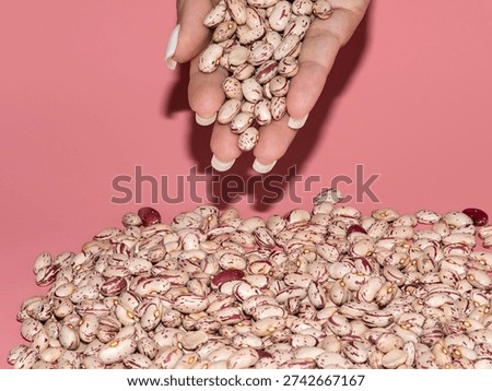 A bulk bag of raw pinto beans in a woman's hand