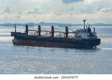 Bulk Carrier Cargo Ship In Ballast Sailing Along Coastline Of Singapore Strait.