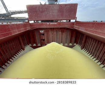The bulk carrier is engaged in loading sulfur cargo for export through maritime transportation.