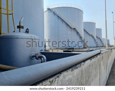 bulk liquid storage tank. large capacity standing tank in the port area for temporary storage of oil before loading into vessels. oil and gas refinery tanks.