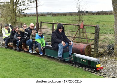 Bulkington, UK - April 1, 2018: A Driver And Passengers Ride On A Miniature Railway Train.