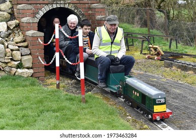 Bulkington, UK - April 1, 2018: A Driver And Passengers Ride On A Miniature Railway Train.