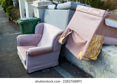 Bulky discarded furniture including armchairs and a settee left outside a house in St Leonards-on-Sea awaiting collection - Shutterstock ID 2282768891