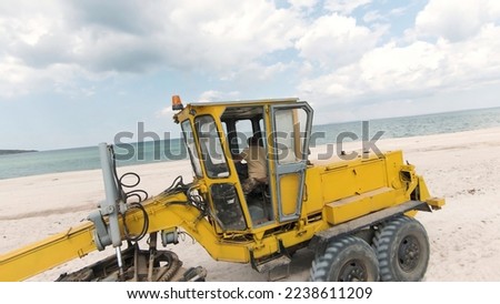 Bulldozer construction site. Shot. Top view of bulldozer driving on beach by sea. Sand mining or construction site on seashore
