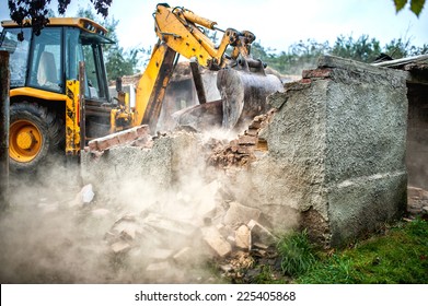 Bulldozer Demolishing Concrete Brick Walls Of Small Building