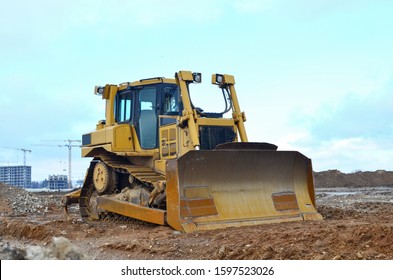 Bulldozer During Of Large Construction Jobs At Building Site.  Crawler Tractor Dozer For Earth-moving. Land Clearing, Grading, Pool Excavation, Utility Trenching And Foundation Digging.