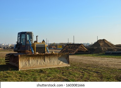 Bulldozer During Of Large Construction Jobs At Building Site. Land Clearing, Grading, Pool Excavation, Utility Trenching And Foundation Digging. Crawler Tractor,  Dozer, Earth-moving Equipment.