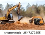 Bulldozer excavator heavy machinery work together to clear excavate land on construction site dust rises as they dig into ground, preparing for upcoming development.