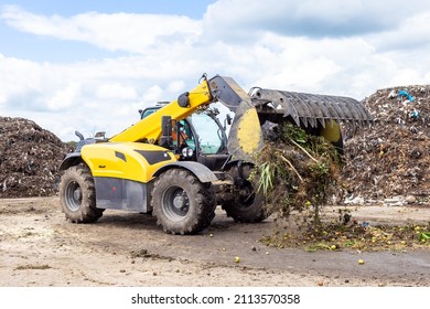 Bulldozer Moving Organic Waste At Compost Recycling Plant. Earth Mover Working On Pile Of Compost In Industrial Facility