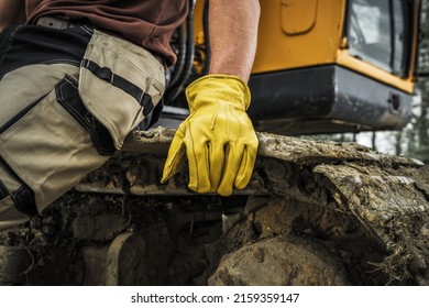 Bulldozer Operator Resting On A Caterpillar Track Close Up. Heavy Duty Machinery Ground Moving Job. 