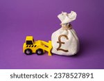 A bulldozer pushes a british pound sterling moneфy bag. Ineffective use of funds. Money down the drain. Financing of dismantling works. Demolition services, land leveling. Industry machinery for rent.